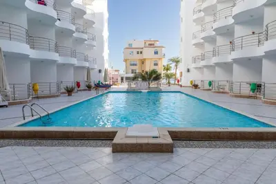 a large swimming pool in a large building at Daily rent studio pool view in Hurghada
