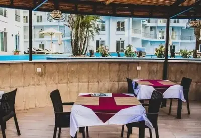a restaurant with tables and chairs and a pool at Aqua Palms Resort Hurghada in Hurghada