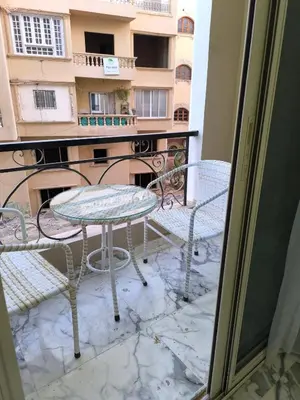 a balcony with a table and chairs and a building at New 2bedroom apartment 7 min drive from Sheraton in Hurghada