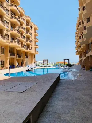 a swimming pool in front of a large apartment building at One Bedroom At Turtle Beach Compound With Private Beach in Hurghada