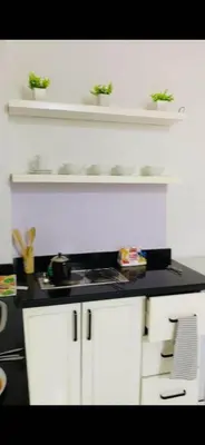 a kitchen with white cabinets and plants on shelves at One Bedroom At Turtle Beach Compound With Private Beach in Hurghada