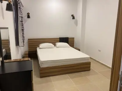 a bedroom with a bed with white sheets at Andreas Residence in Hurghada