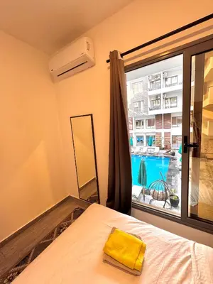a bedroom with a bed and a large window at Imperial resort Hurgarda in Hurghada