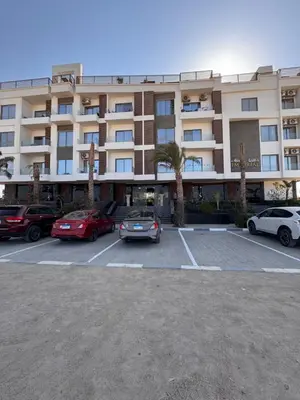 a large building with cars parked in a parking lot at Imperial resort Hurgarda in Hurghada