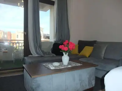 a living room with a couch and a table with flowers at Victoria Aldau Heights Hurghada rent one bedroom Apartment in Hurghada