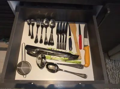 a drawer filled with utensils on a white cutting board at Victoria Aldau Heights Hurghada rent one bedroom Apartment in Hurghada