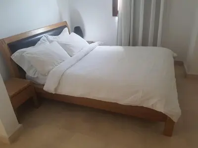 a bed with white sheets and pillows in a room at Villa, with heated Pool and Lagoon in Hurghada