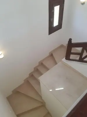 a room with a staircase with a chair and a mirror at Villa, with heated Pool and Lagoon in Hurghada