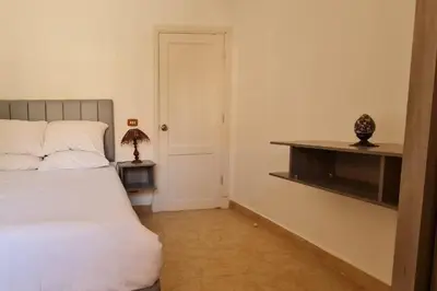 a bedroom with a white bed and a white door at Nile Front Luxor Apt Sleeps 6 with Pool in Luxor