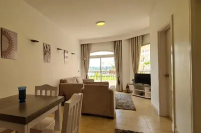 a living room with a table and a dining room at Nile Front Luxor Apt Sleeps 6 with Pool in Luxor