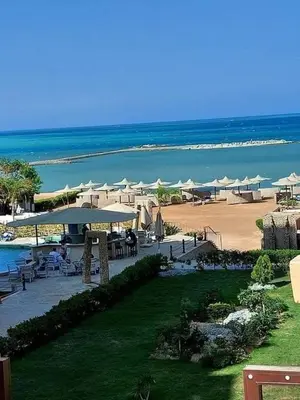 a beach with tables and umbrellas and the ocean at Turtles Beach resort hourghada Studio view sea view pool private beach jacuzzi pools air-conditioned restaurant on the beach jacuzzi security and a large sunny balcony in Hurghada