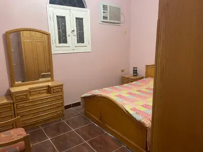 a bedroom with a bed and a dresser and a mirror at MelissaKato in Naj‘ al Maḩaţţah