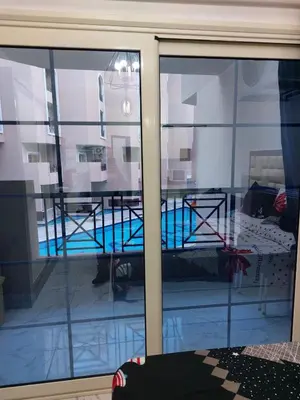 a view of a swimming pool through a window at Juliana beach in Hurghada