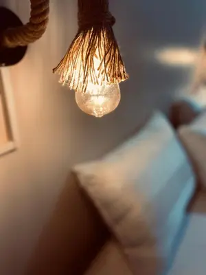 a light hanging over a bed with a pillow at Wanees Hostel in Aswan