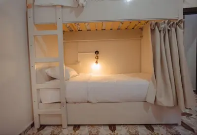 a bedroom with a bunk bed with a ladder at Wanees Hostel in Aswan