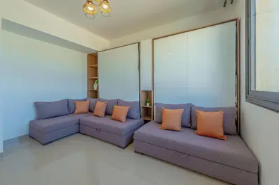 a living room with blue couches and orange pillows at Peaceful 1BR studio at G-Crib El Gouna in Hurghada