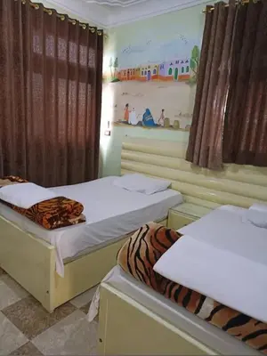 two beds in a room with a tiger print on them at شقق للإيجار بأسوان in Aswan