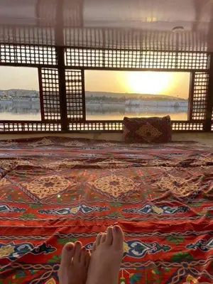 a person with their feet on a rug on a floor at Relaxing Felucca Trips in Aswan