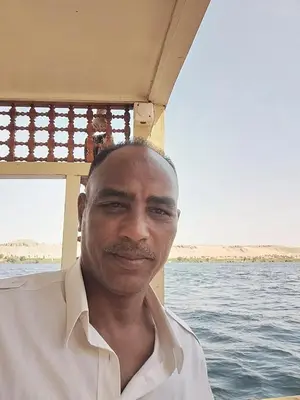 a man sitting on a boat in the water at Relaxing Felucca Trips in Aswan
