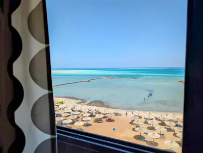 a view of a beach with umbrellas and the ocean at Das Nistkästchen in Hurghada in Hurghada
