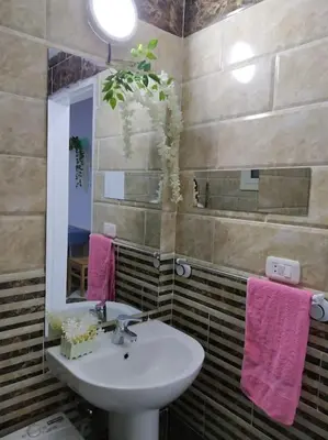 a bathroom with a sink and a mirror and pink towels at Sheraton Plaza house near the beaches and near New Marina studio 428 in Hurghada
