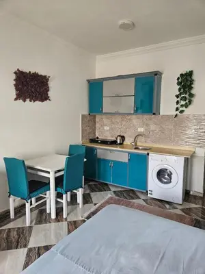 a kitchen with blue cabinets and a table and a sink at Sheraton Plaza house near the beaches and near New Marina studio 428 in Hurghada