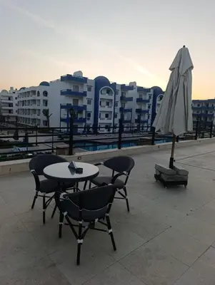 a table and chairs and an umbrella on a roof at Studio FOR RENT IN ELWAZRA EREA BEFOR EL GOUNA 5 MINUTES ONE BEDROOM in Hurghada
