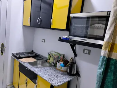 a small kitchen with a sink and a microwave at Studio FOR RENT IN ELWAZRA EREA BEFOR EL GOUNA 5 MINUTES ONE BEDROOM in Hurghada