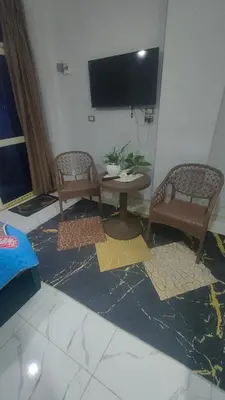 a living room with two chairs and a table and a tv at Studio FOR RENT IN ELWAZRA EREA BEFOR EL GOUNA 5 MINUTES ONE BEDROOM in Hurghada