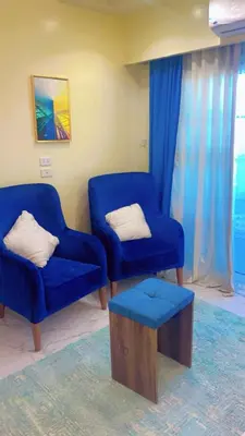two blue chairs and a stool in a living room at جوليانا بتش in Hurghada