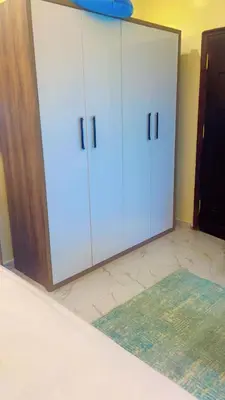 a white cabinet in a room with a rug at جوليانا بتش in Hurghada