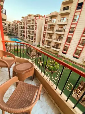 a balcony with chairs and tables and some buildings at Luxor family apartment in Luxor