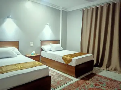 a hotel room with two beds and a window at Luxor family apartment in Luxor