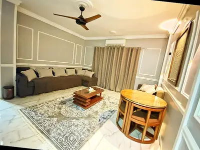 a living room with a couch and a table at Luxor family apartment in Luxor