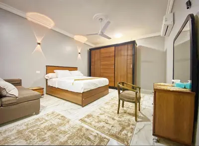 a bedroom with a bed and a chair and a couch at Luxor family apartment in Luxor