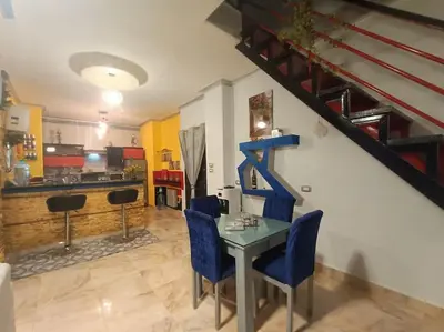 a living room with a table and blue chairs at Apartment Duplex Flat - Private Garden - 2 Floors in Hurghada