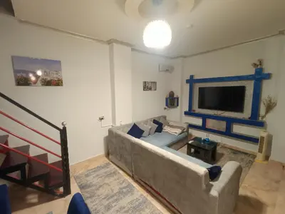 a living room with a couch and a tv at Apartment Duplex Flat - Private Garden - 2 Floors in Hurghada