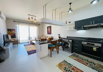 a kitchen and living room with a table and a dishwasher at Cozy 3 Bedrooms Apartment at Cyan El-Gouna in Hurghada