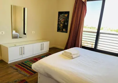 a bedroom with a white bed and a mirror at Cozy 3 Bedrooms Apartment at Cyan El-Gouna in Hurghada