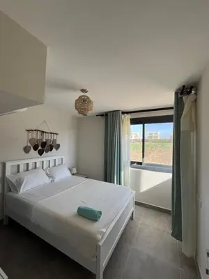 a bedroom with a white bed and a large window at Cozy 2BR Seaview loft in Mesca Somabay in Hurghada