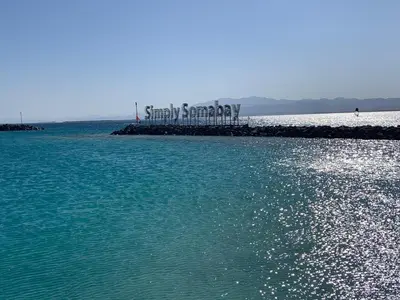 a large body of water with a sign on a pier at Cozy 2BR Seaview loft in Mesca Somabay in Hurghada