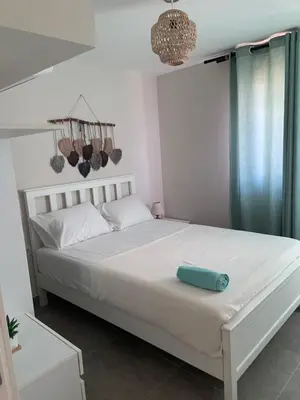 a bedroom with a bed with a blue pillow on it at Cozy 2BR Seaview loft in Mesca Somabay in Hurghada