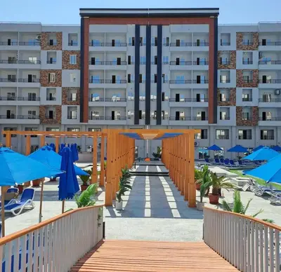 a resort with blue umbrellas and a building at Tiba gollden resort in Hurghada