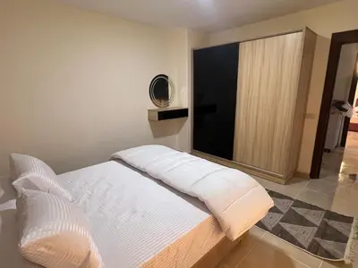 a white bed in a room with a large window at Tiba gollden resort in Hurghada