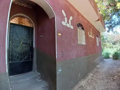 a door to a house with a red wall at Sobhy Kana House in Aswan