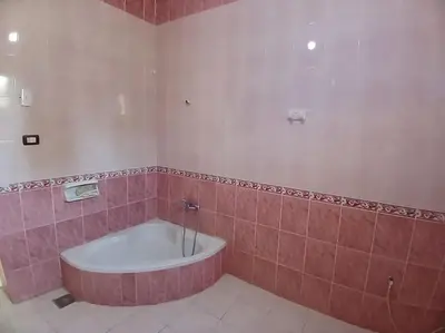 a bathroom with a tub in a pink tiled room at Sobhy Kana House in Aswan