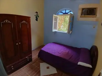 a bedroom with a purple bed and a window at Sobhy Kana House in Aswan