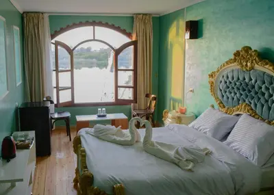 a bedroom with a large bed with a swan on it at Eyaru Palace Nile View in Luxor