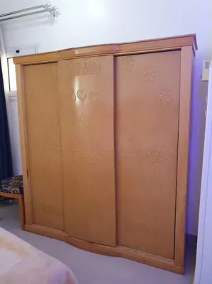 a wooden wardrobe with flowers on it in a room at Villa Omar El Sharif Studio n1 in Luxor