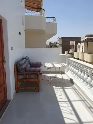 a balcony with a chair and a table on a building at Villa Omar El Sharif Appartement studio n2 in Luxor